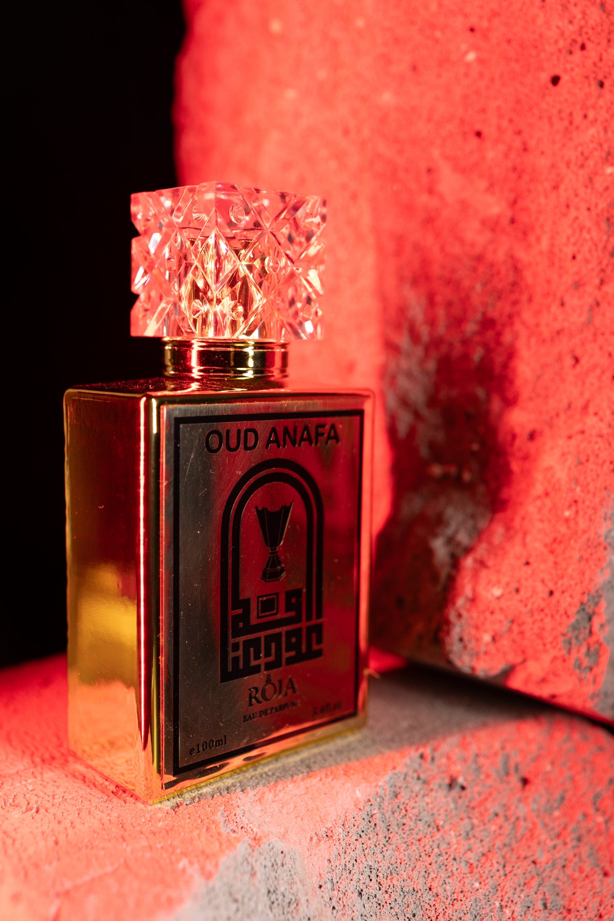 Roja Fume Oud Anafa 100ml bottle in warm red light